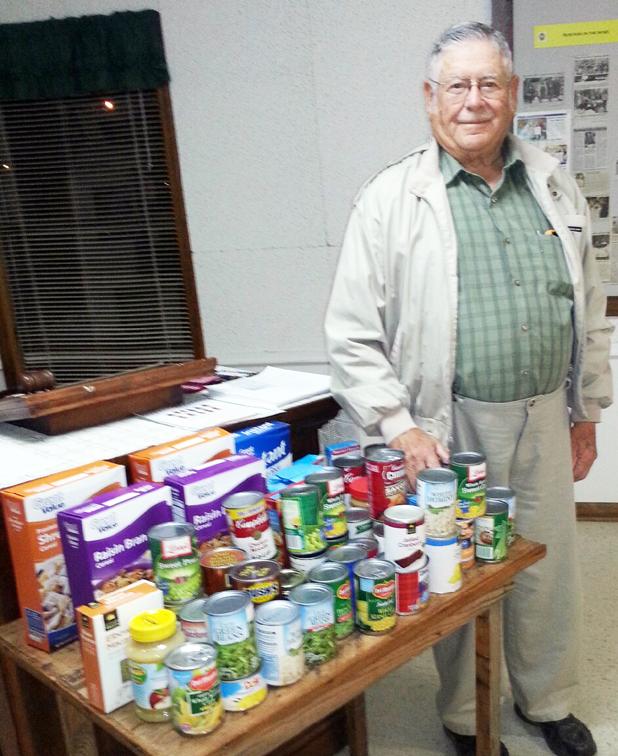 Loaves and Fishes representative, Bill Kirk, addresses Grand Junction Ruritans Bill Kirk, representative of Loaves and Fishes, is shown with some of the food members of the Grand Junction Ruritan Club donated after he spoke at their November meeting.