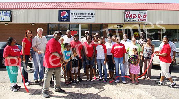 Roosevelt Bowers, undoubtedly operating on a few short hours of sleep after a long night of cooking, cuts the ribbon for the BBQ Store in Whiteville.