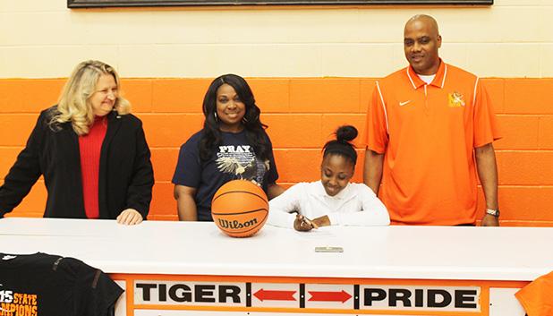 Averyale Joy signs to play basketball for Northwest Mississippi Community College. Pictured (l-r) MHS Principal Darlene Cardwell, Thella Joy (Averyale’s mother), Averyale Joy (seated) and MHS Lady Tiger Head Coach James Burkley 