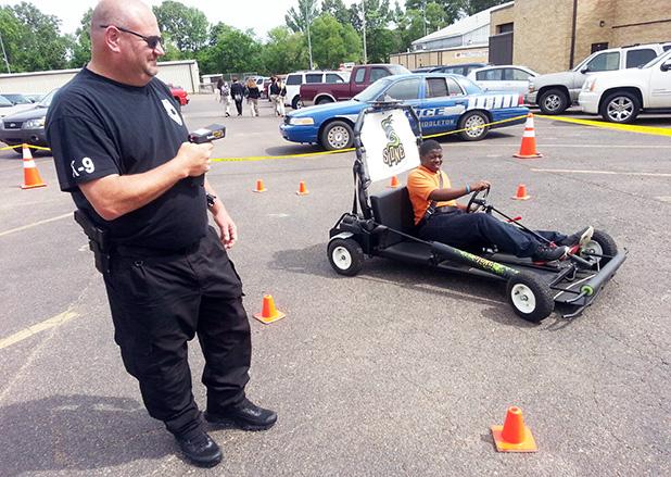 Middleton P.D. holds traffic safety day Middleton Police Department held a traffic safety day at the high school. Four enforcement agencies participated. Different displays and activities allowed students to see and experience the dangers of impaired driving. Pictured, Middleton K-9 Officer Richie Webb remotely assumes operation of the vehicle driven by student Rontavious Poplar. The officer can control the vehicle so it drives normally or simulates impaired driving as the student attempts to negotiate an obstacle course.
