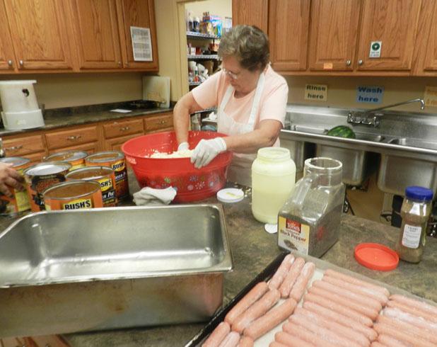 Over 26,000 free meals served! Volunteer Glynda Mitchell prepares slaw for the 170 meals Food for Friends will deliver Saturday.