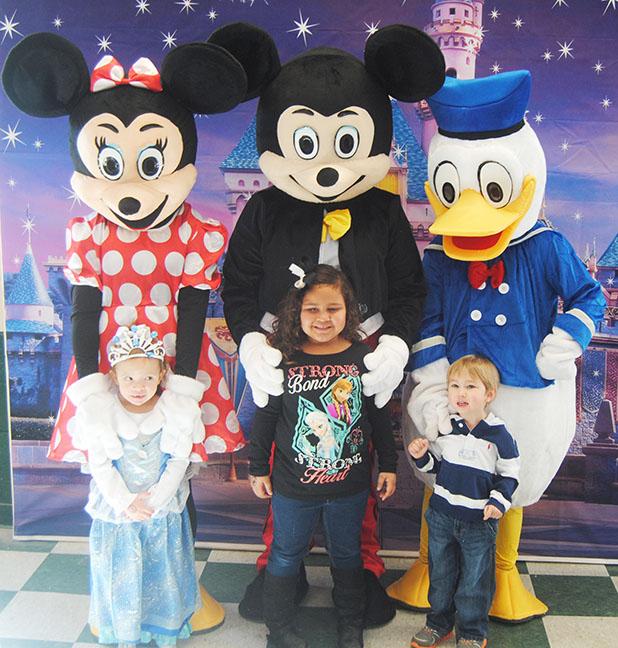 Laynee JoAnna (daughter of Cassie Holmes), Mya Overton (daughter of Lindsey Overton), and Maddox Morein (son of Kim and David Morein) pose for a picture with Minnie Mouse, Mickey Mouse and Donald Duck.