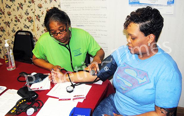 Cassandra Bufford, a RN at the Hardeman County Community Health Center takes Nikita Dennis' blood pressure during the mini health fair at Greater Victory Church on Saturday, March 12.