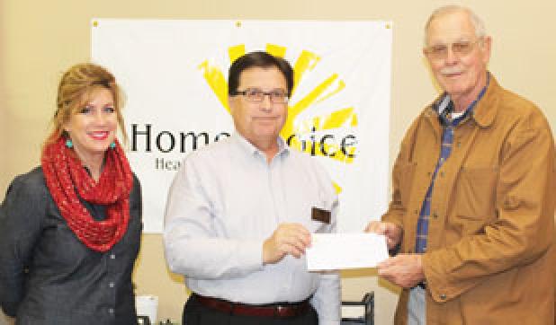 Pictured: Mary McCammon (RN with HomeChoice) and Don Young (HomeChoice Director of Operations) present the donation check to Bo Lane with Loaves and Fishes. 