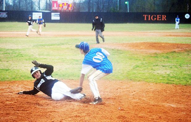Middleton’s Hunter Dickey slides in under Hornsby Pitcher Kyle Sipes attempted tag for a score.