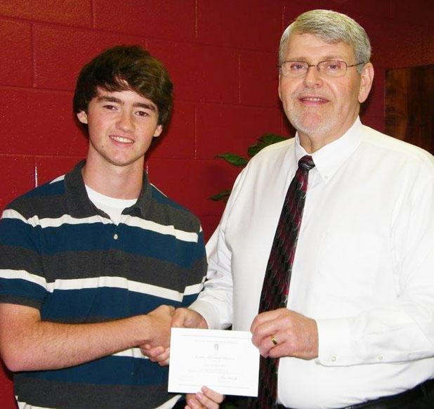 Ron Canada is shown presenting a Letter of Commendation to John Ferguson from the school and National Merit Scholarship Corporation. 