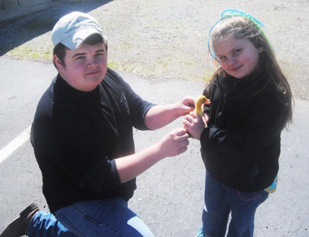 Truman Mayfield allows Bethany Hopper to hold a baby duckling at the petting zoo.
