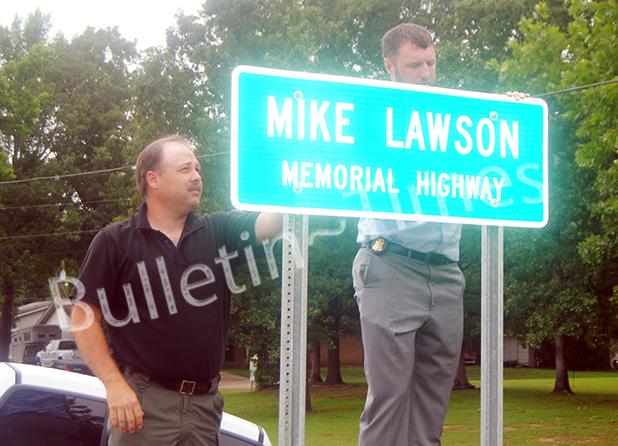 Former chief deputy, county commissioner honored Mike Lawson’s sons, Chad Lawson and Scotty Lawson unveil a sign honoring their dad, who served Hardeman County in many capacities for more than 25 years, by renaming a two mile stretch of Hwy. 125 South in his honor.