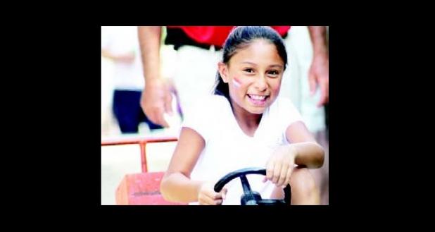 The Children’s Patriotic Festival included games for children, such as pulling a wagon with a miniature, pedal powered, tractor.