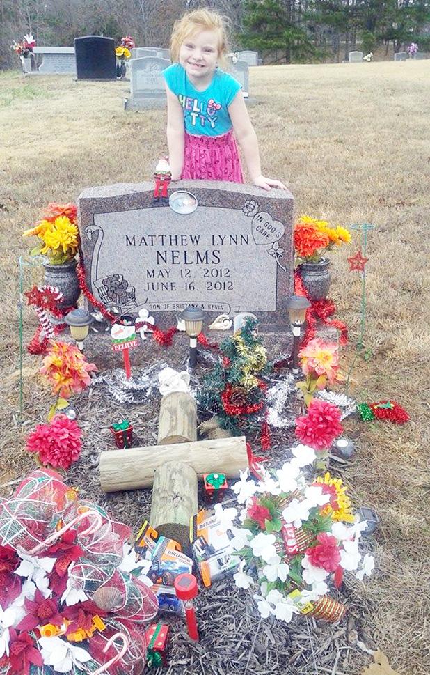 Kailey Tillmon is pictured at her baby brother’s grave after her letter to Santa was answered on Christmas and Santa left some treats for her baby brother on his grave.