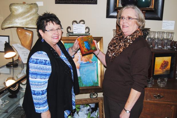 Owner Deborah Turner Brasfield (left) and local artist Jackie Smith examine a work of art. 