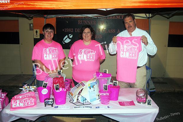 Brandon Burvee, Kathy Weaver and David Tyner sell Pink Out shirts and other items during the Middleton Homecoming game. 