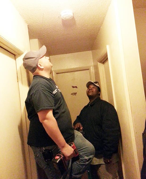 State Fire Marshal’s office celebrates milestone anniversary with service Charles Thompson (left) inspects the smoke alarm he has just installed as Property Manager James Woods looks on. This alarm was one of over 100 installed in Bolivar in just one day.