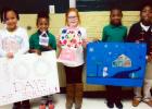 Winners were, pictured (l-r ): First place, Erkijah Davis with her shirt of 100 buttons; second place, Zion Collins with a house made with 100 Q-tips; third place, Isabella Lax with a bank with 100 gum balls. Honorable mention, Brandon Bufford with drawing with 100 snowflake;  honorable mention, Akevious Haddix with a necklace made with 100 gummy savers.