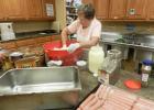 Volunteer Glynda Mitchell prepares slaw for the 170 meals Food for Friends will deliver Saturday.   