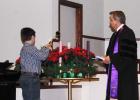 Noah Cody (left) lights the Advent Wreath of First United Methodist Church during the Ecumenical Service on Sunday, November 30 as Dr. Paul Clayton watches.