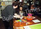 Grand Junction Library holds children’s program Wanza Taylor, head librarian at Grand Junction, helps Patrick and Kylee Sarogham with a craft project.