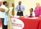Robert Davis, Jr., Cassandra Bufford, and CEO Mary Heinzen from the Hardeman County Community Health Center talk with a patron. Photo by Ginger Tester. 