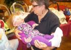 Volunteer Betty Thompson carries Haileigh to a waiting resident at a Pine  Meadows therapy session.