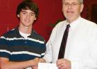 Ron Canada is shown presenting a Letter of Commendation to John Ferguson from the school and National Merit Scholarship Corporation. 