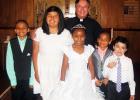 Members receiving Communion: Cynthia Macias, Raquel Harry, Demetrius Edgeston, Jaylen Edgeston, Diego Chavira, with Rev. Fr. W.H. Arnold in back.