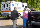 Witnesses and officers look on after Cornelius Hussey is loaded into ambulance.