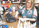 The Vaughan Oil Company is donating hand sanitizer to first responders in Hardeman County, using suppliers from the State of Tennessee to do the job. Photo: Volunteer Janna Vaughan labels the bottles.  