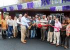 Friends, family and local officials look on as Gwen Moody cuts the ribbon on the third location of Moody’s Auto Sales.